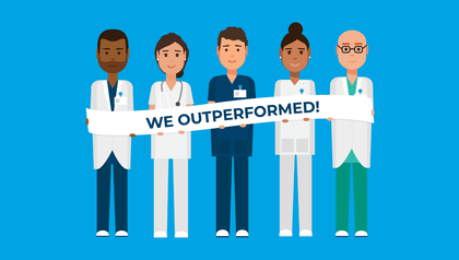 male and female surgical residents holding a banner that reads we outperformed